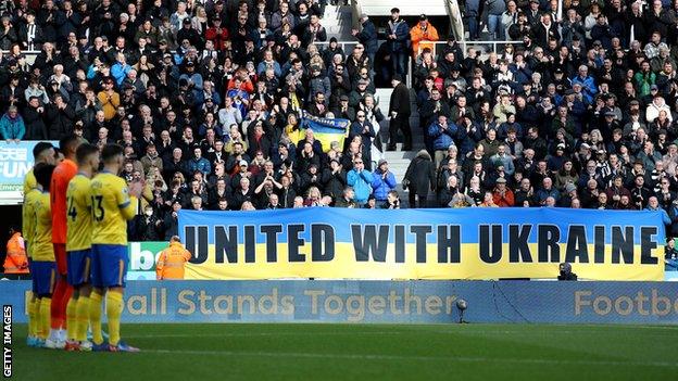 Brighton, wearing their third-choice yellow and blue kit in solidarity with Ukraine join in a minute's applause as Newcastle fans unveil a banner