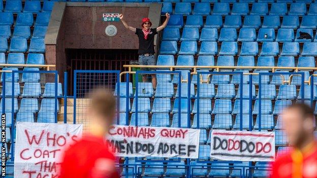 Mike Edgeworth took three banners to the game, one of which said 'mae’n dod adref', which is Welsh for 'it's coming home'