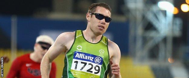 Jason Smyth crosses the line after retaining his T13 100m title in Doha