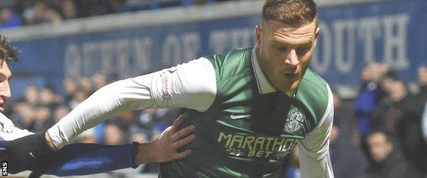 Hibs striker Anthony Stokes holds off a Queen of the South defender