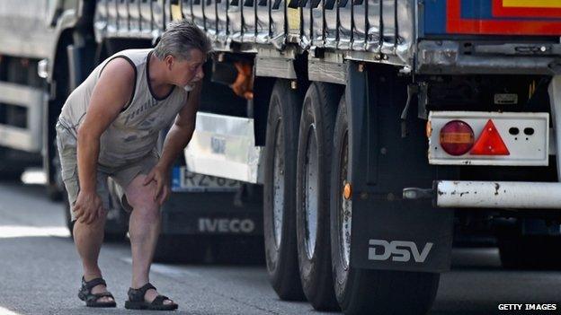 A driver looks under a lorry in Calais, 25 June, 2015