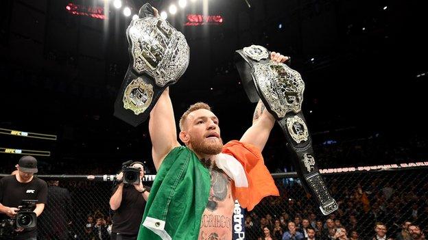 Conor McGregor celebrates becoming the first fighter to hold two UFC titles simultaneously in 2016