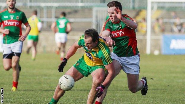 Michael Murphy stoops to win possesion ahead of Mayo's Shane Nally