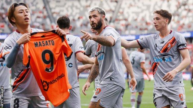 Brisbane Roar team-mates Riku Danzaki and Charlie Austin pay tribute to former Roar player Masato Kudo after he died aged 32