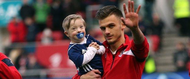 Bristol City's Jamie Paterson leads Nottingham Forest fan Tyler Cove out onto the pitch at Ashton Gate