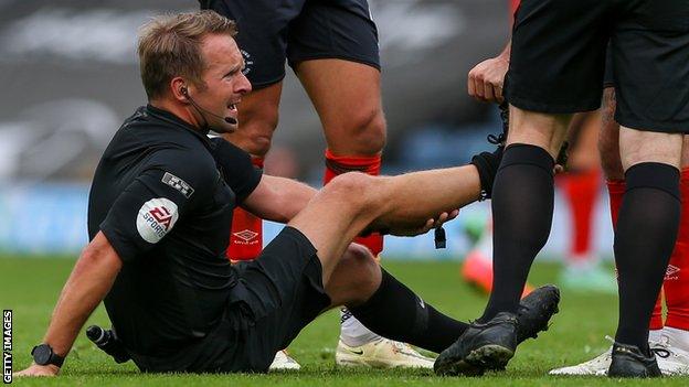 Referee Oliver Langford receives treatment