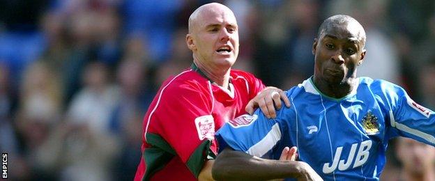 Cardiff City defender Rob Page challenges Wigan Athletic striker Jason Roberts during a Championship fixture at the DW Stadium in August 2004