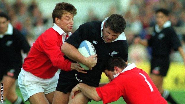 Sean Fitzpatrick is tackled by the Lions' Rob Andrew (left) and Nick Popplewell