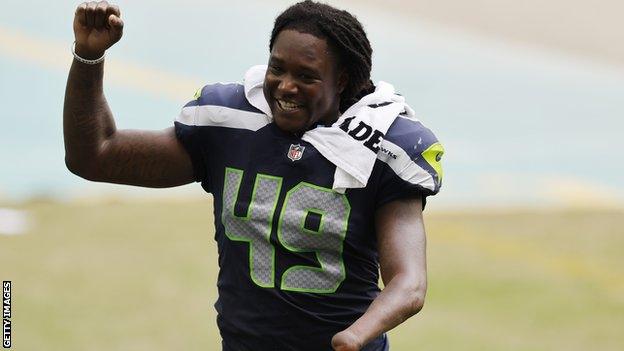 Shaquem Griffin holds his hand up while playing for Seattle Seahawks