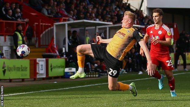 Newport's Will Evans stretches to beat Nicholas Tsaroulla of Crawley to the ball