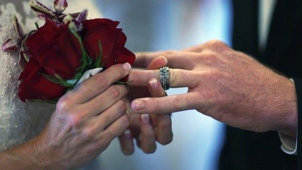 A couple exchanging rings at their wedding