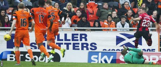 Lewis Vaughan (right) flicks the ball over Dundee United keeper Cammy Bell to score Dumbarton's second goal