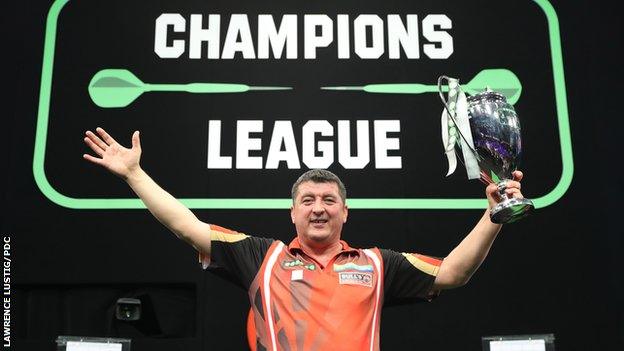 Mensur Suljovic lifts the Champions League of Darts trophy