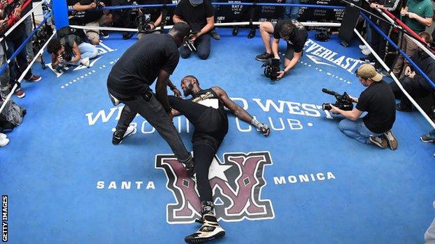 Wilder is stretched off thoroughly by his team before workouts in Tuscaloosa