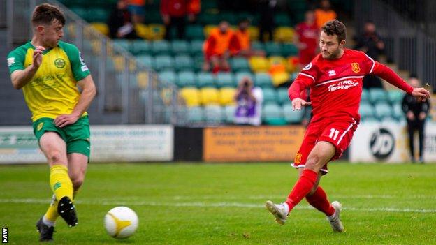 James Davies scores one of his two goals for Newtown at Caernarfon.