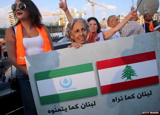 Supporters of Lebanese Christian leader Michel Aoun's opposition Free Patriotic Movement (FPM) hold a placard reading in Arabic "Lebanon as we see it" (R) and "Lebanon how they wish it to be"