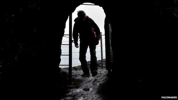 Walker enters cave along Gobbins path