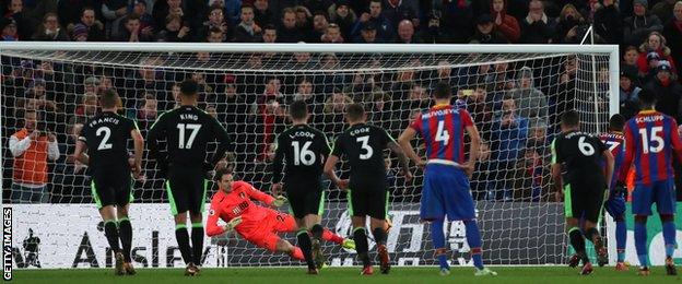 Christian Benteke's penalty is saved by Asmir Begovic as Luka Milivojevic (number four) looks on