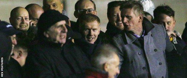 Paul Scholes (centre) watches on from the stands at Moor Lane