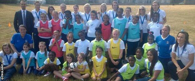 Mark Sampson and his England squad pose with pupils from Essendine School and Jubilee School at Kensington Palace