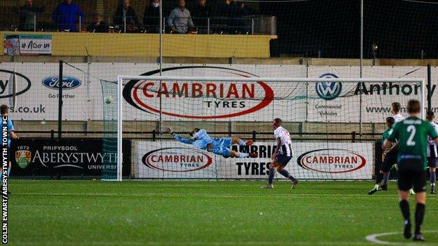 Jonathan Evans' shot flies into the net during Aberystwyth's win over Flint with dad Mel - and friends - watching on from an open-top bus behind the goal