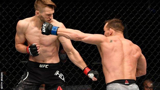 Michael Chandler punches Dan Hooker during his win at UFC 257