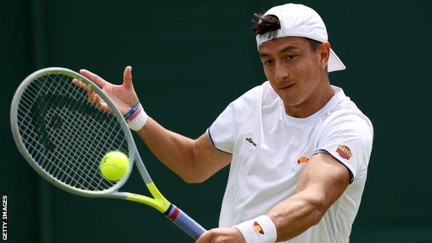 Ryan Peniston hits a return in his match against Steve Johnson at Wimbledon