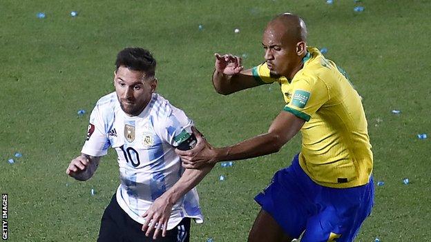 Argentina captain Lionel Messi (left) competes for the ball with Brazil's Fabinho (right)