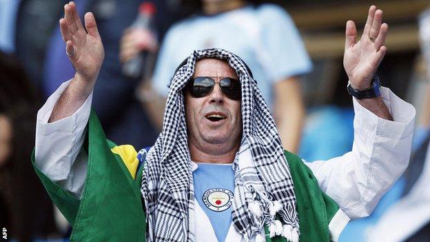 A Manchester City supporter dons a traditional Middle Eastern headdress to celebrate the buyout of the club by the Abu Dhabi United Group