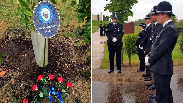 Memorial sign and police officers lining a road