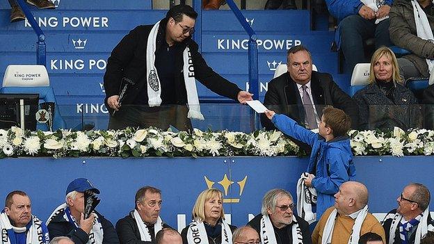 Vichai Srivaddhanaprabha's son Aiyawatt is handed an envelope by a young fan during Leicester's game against Burnley