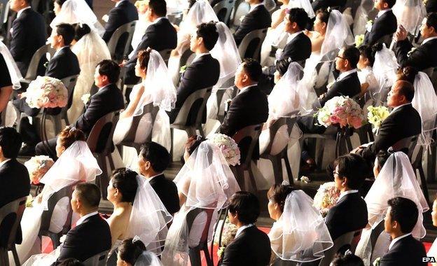 A view of the couples sitting in their wedding outfits at the venue