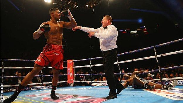 Dillian Whyte hangs over the final rope after being knocked down by Anthony Joshua