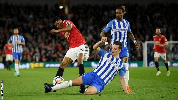 Marcus Rashford is tackled by Lewis Dunk