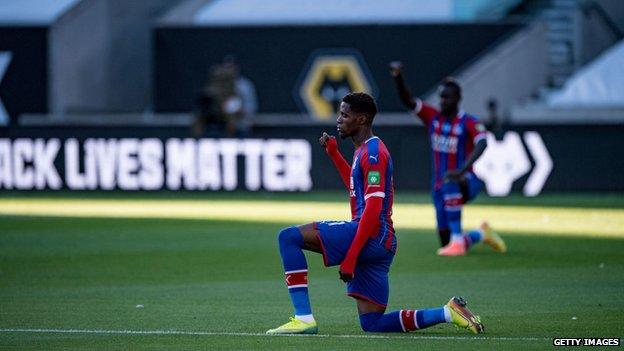 Crystal Palace forward Wilfried Zaha takes the knee