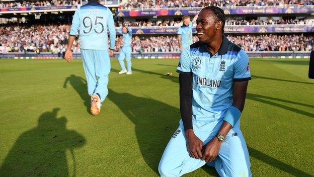 Jofra Archer kneels in celebration after winning the Cricket World Cup with England