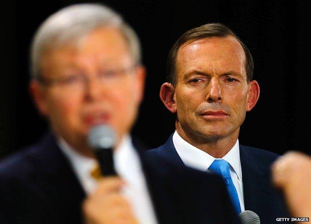 This picture taken on 21 August, 2013 shows Tony Abbott listening as Kevin Rudd speaks during a people's forum in Brisbane