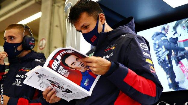 Alex Albon reads a magazine