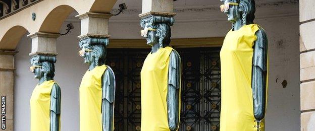 The columns of a building in Utrecht are draped in yellow jerseys