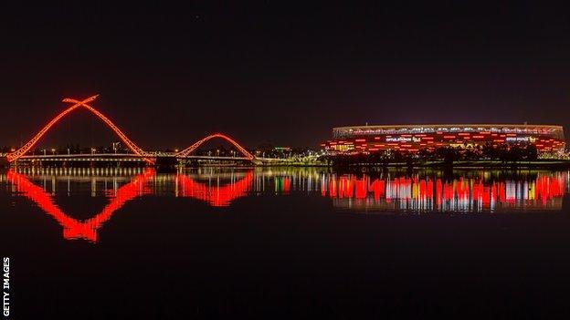 Optus Stadium and the Matagarup bridge are lit up red to celebrate the arrival of Manchester United