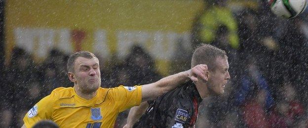 Ballymena defender Johnny Taylor challenges Jordan Owens in the Seaview rain