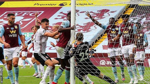 Aston Villa goalkeeper Orjan Nyland holds the ball behind the goalpost