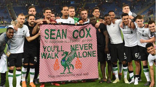 Liverpool players hold flag showing support for injured fan Sean Cox