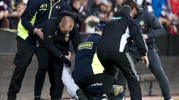A Hearts fan is restrained after running at Neil Lennon