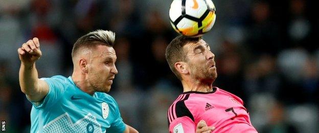 James McArthur heads the ball against Slovenia