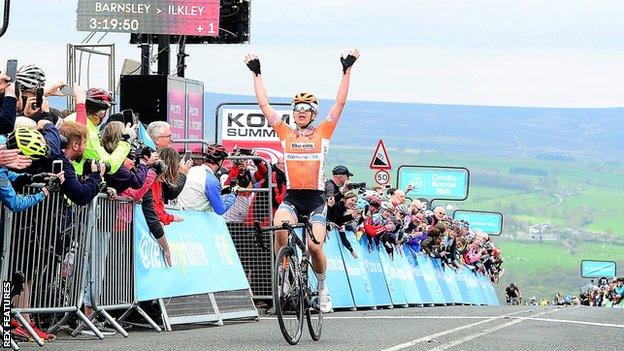 American Megan Guarnier raises her hands in celebration as she crosses the line after winning the 2018 women's Tour de Yorkshire