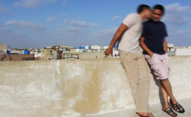 Two men kissing on rooftop