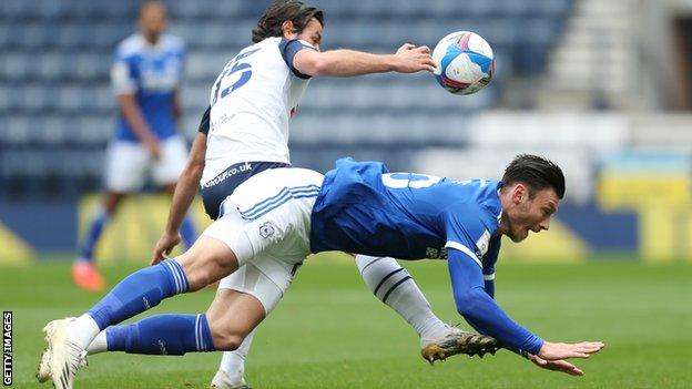 Kieffer Moore tumbles to the ground after a challenge with Preston's Joe Rafferty