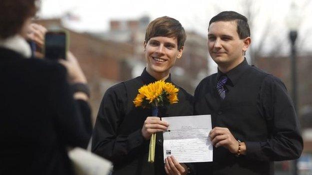 Justin Lewis and Shawn Williams show off their marriage licence after having to drive to Montgomery, Ala., to get it after being refused in Lee County on 9 February 2015