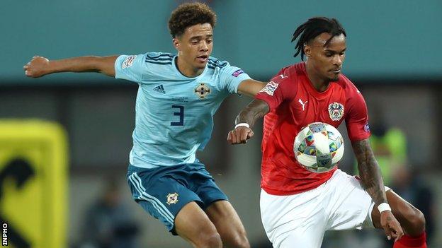 Jamal Lewis and Valentino Lazaro challenge for possession during the match in Vienna